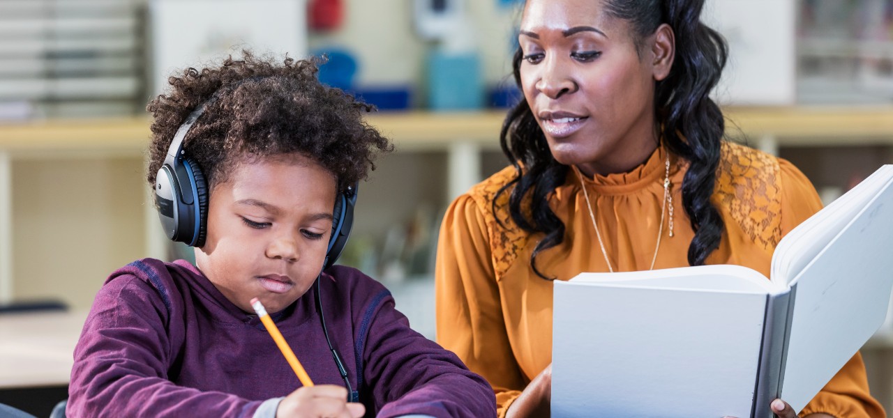 African-American teacher and elementary school student stock photo
